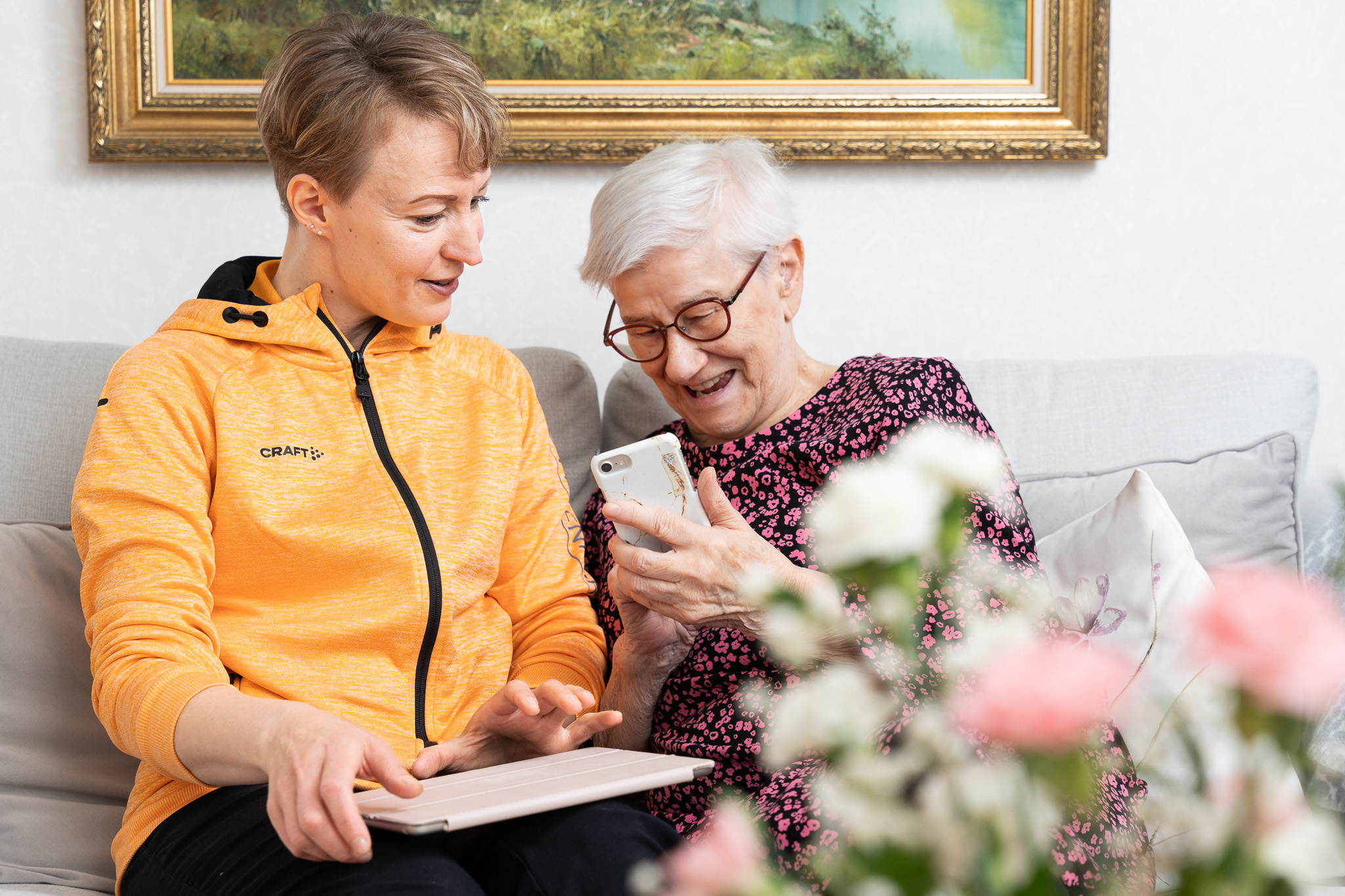 KotiSeniorin työntekijä sohvalla asiakkaan kanssa